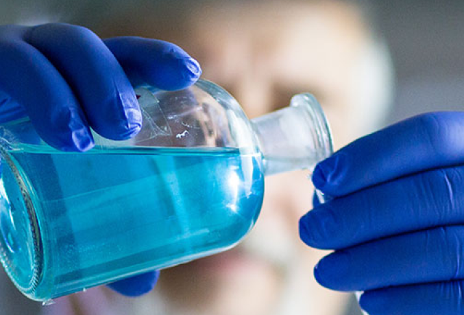 Scientist pouring liquid from a bottle