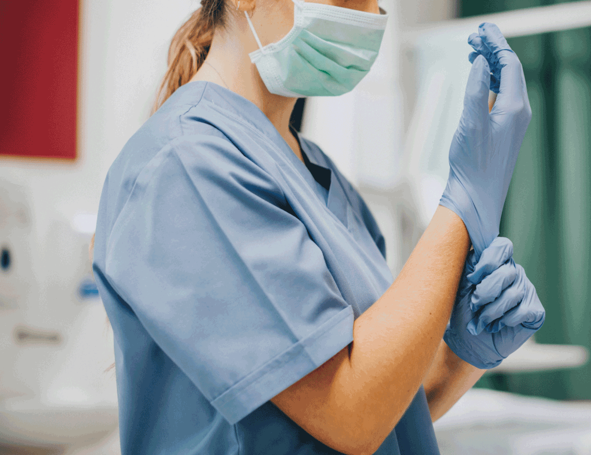 Nurse putting on gloves and a mask
