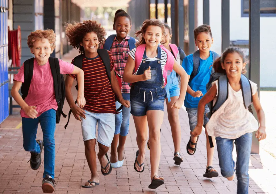 Group of young school students running with their backpacks