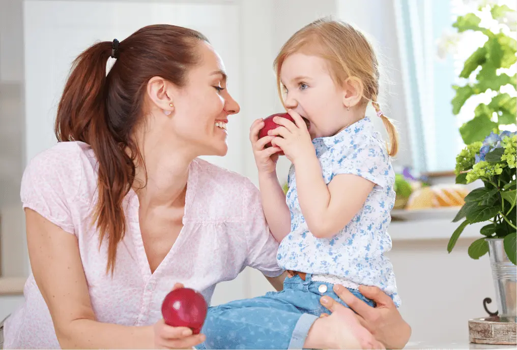 Mom and daughter eating apples