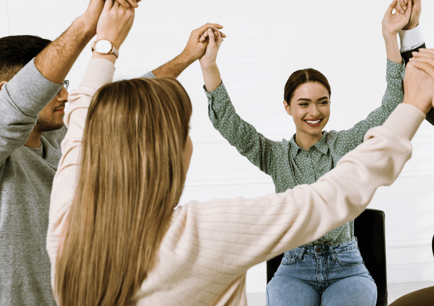 Group of people holding hands in the air