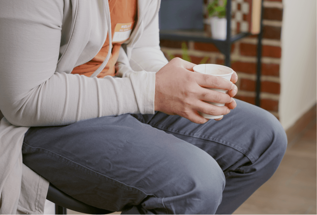 Student sitting and holding a cup of coffee