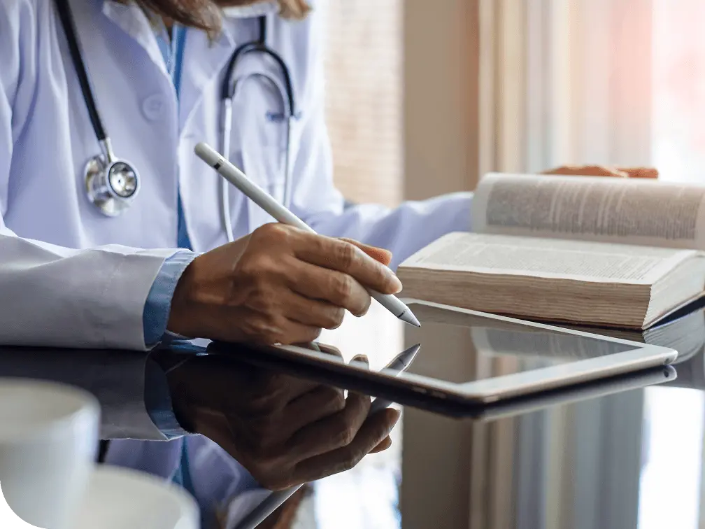 Doctor reading and taking notes from a book