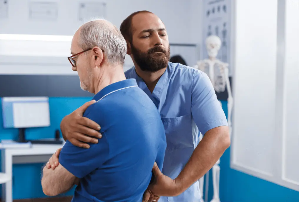 Chiropractor assisting patient with back pain