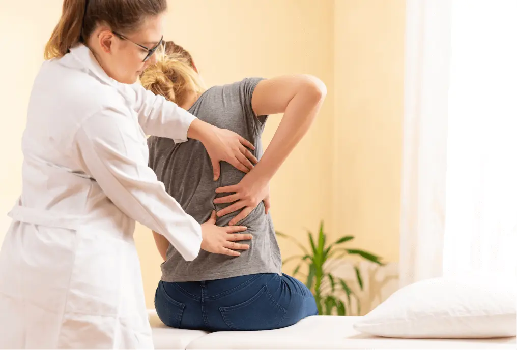 Chiropractor assisting patient with back pain