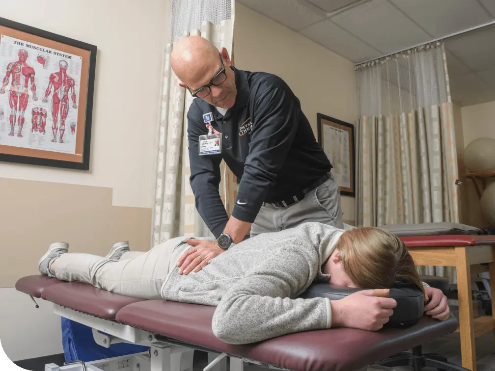 Physical Therapist stretching a patients lower back