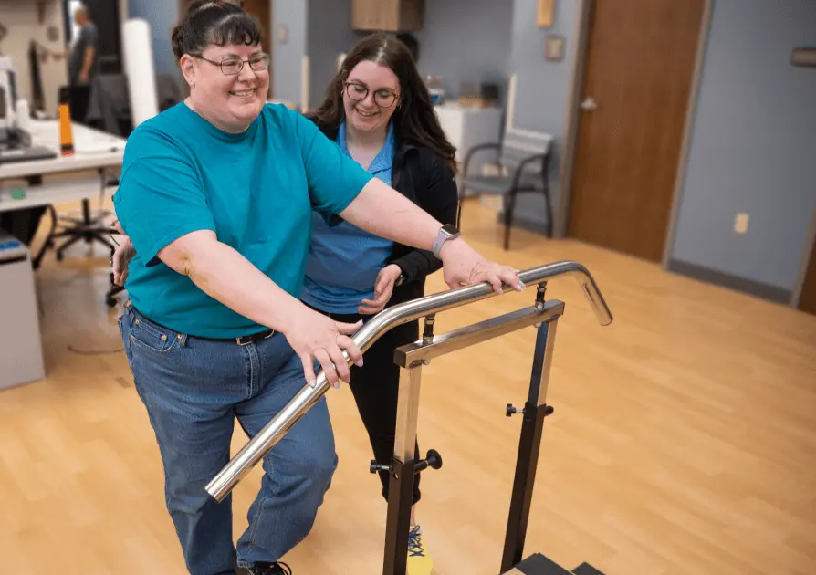 Physical Therapist helping a patient stand up