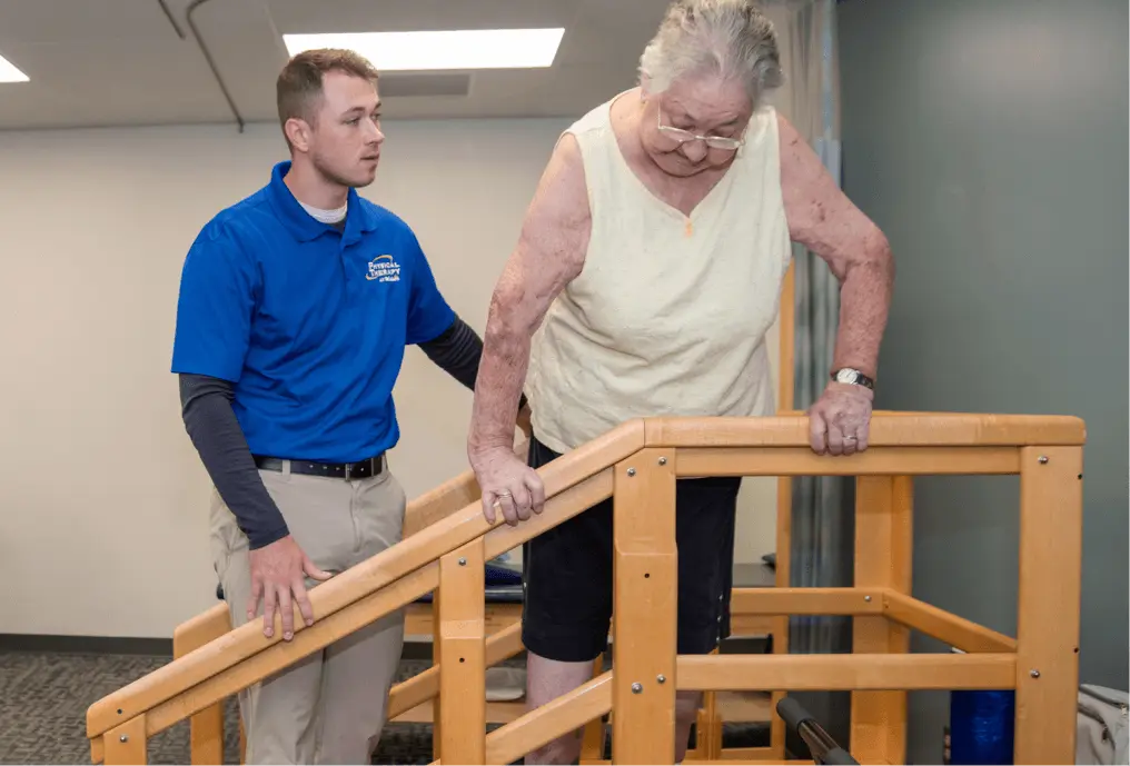 Physical Therapist helping patient walk down stairs