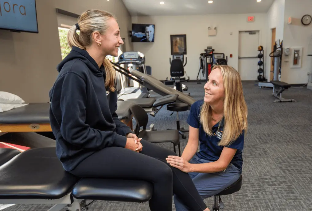 Physical Therapist looking at patient's knee