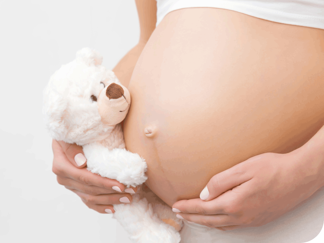 Teddy bear next to pregnant belly