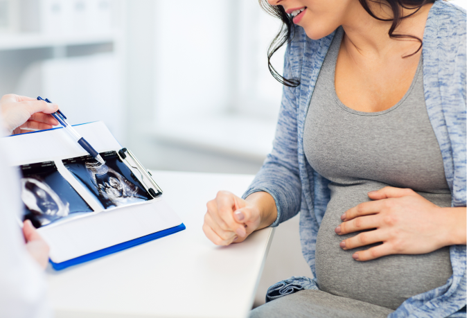 Pregnant woman looking at ultrasound images