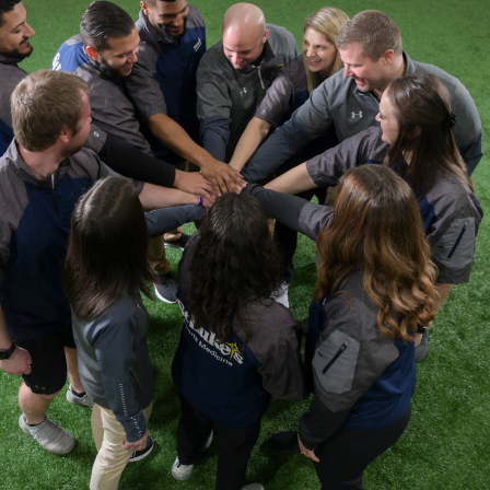 Group of coaches with hands together